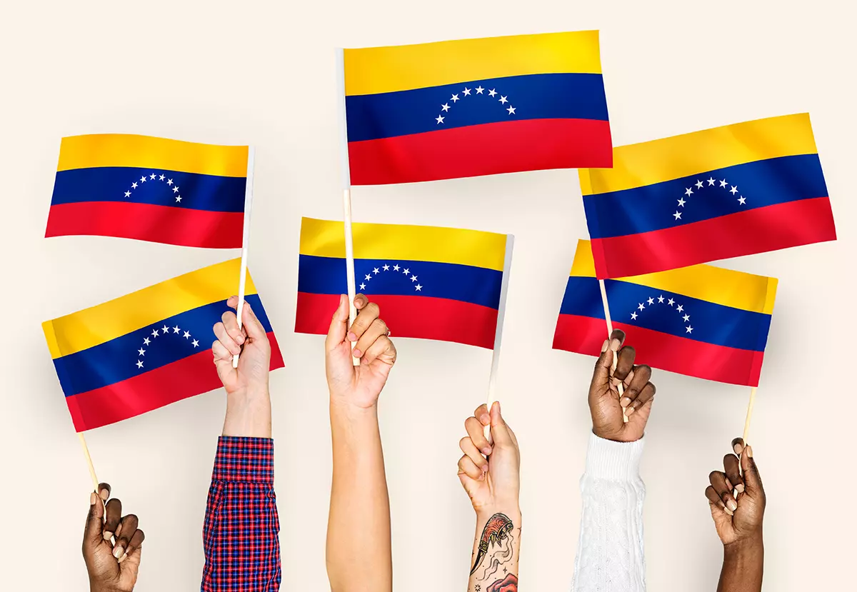 Varias personas levantando la bandera de Venezuela porque adobe restaura su servicio en el país.