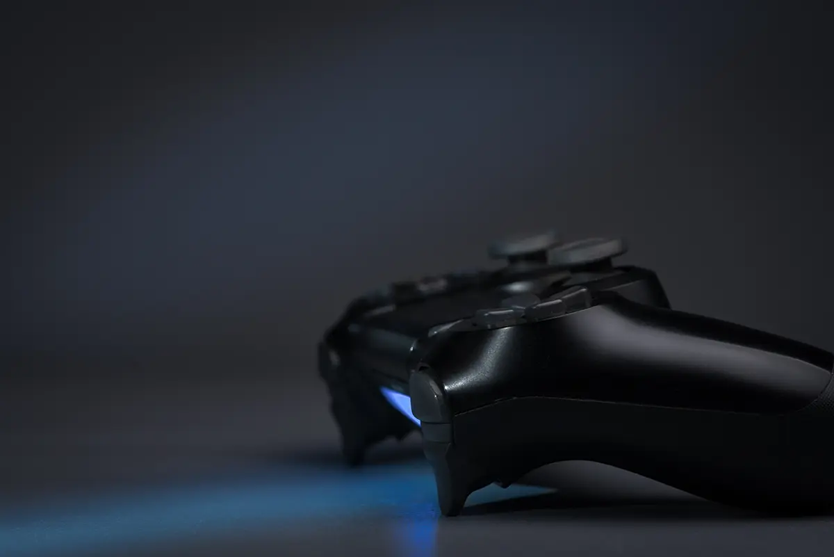 fondo negro con un control de videojuego sobre una superficie, representando la que la filtración de Zynga afectó a 170 millones de cuentas.