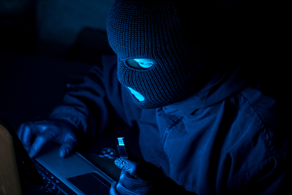 Persona frente a computadora con capucha de ladrón, representando como Clip sufre filtración masiva de datos de usuarios.