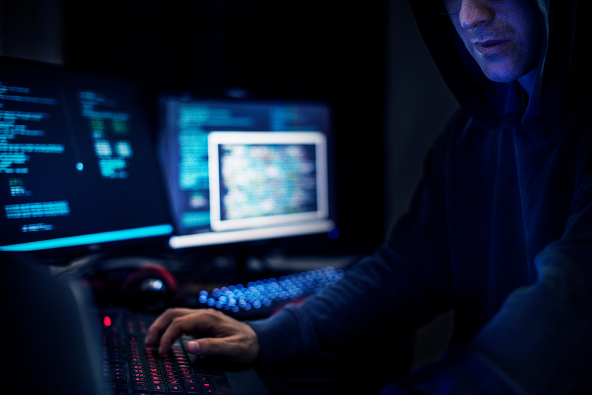 Hombre frente a varias computadoras, crackers realizan ciberataques cada 39 segundos