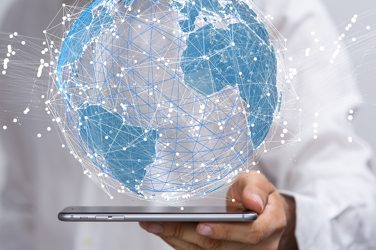 Persona tomando con su mano una tableta con un mundo digital conectado a las redes flotando sobre ella indicando por qué estalló la burbuja de las empresas puntocom