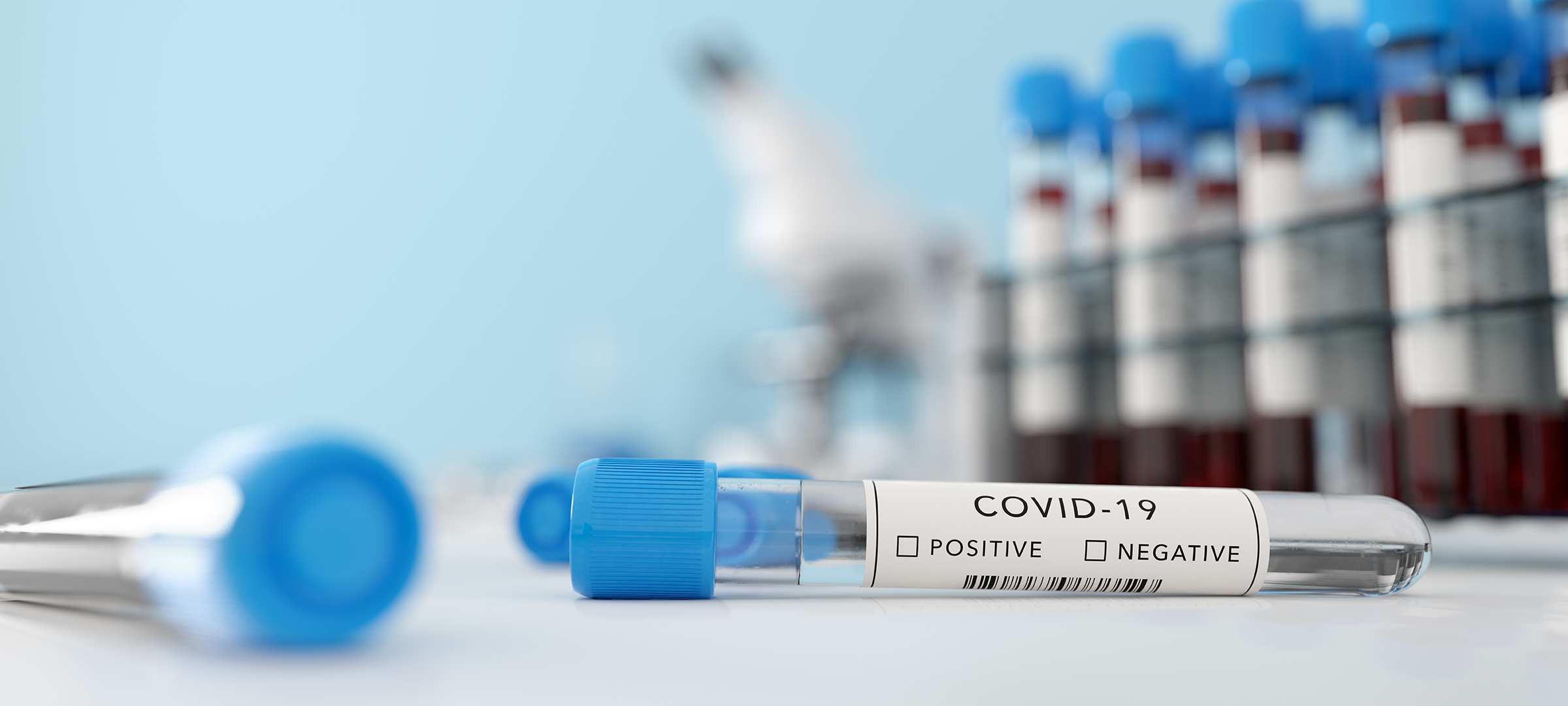 Fondo desenfocado con viarios frascos de medicinas sobre una mesa y en primer plano una vacuna de COVID-19 que Elon Musk CEO de Tesla minimiza la amenaza del coronavirus