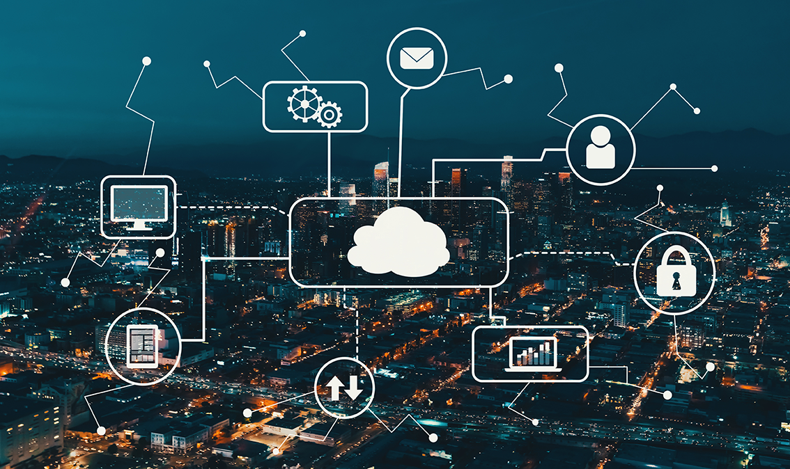 foto panorámica de ciudad de noche con imágenes de la nube y tecnología en primer plano, mostrando cómo las áreas de TI habilitan la competitividad en las empresas