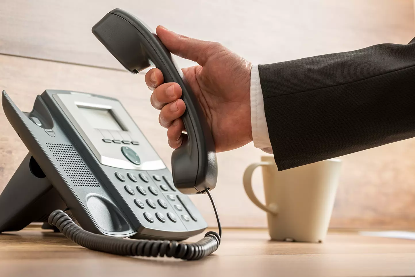 Persona levantando el teléfono, consejos para reducir la tasa de abandono en un service desk