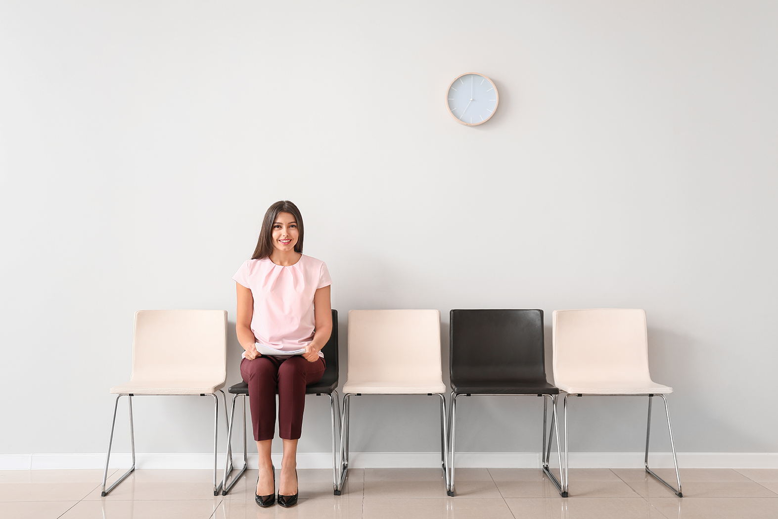 Mujer sentada en una banca esperando su turno para entrevista laboral, representando cómo prepararse para encontrar el trabajo soñado