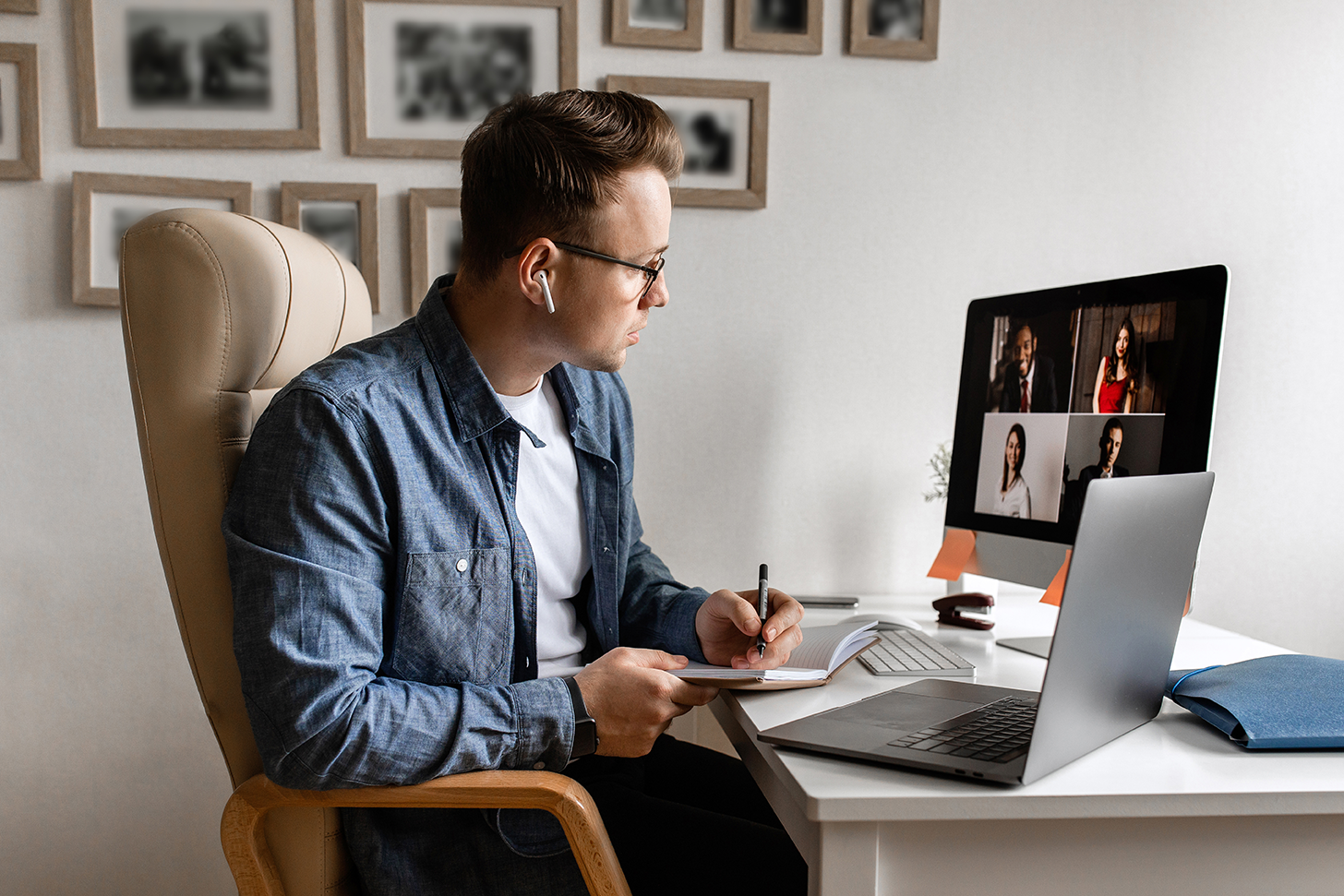 Hombre en el escritorio de su casa frente a su computadora teniendo una sesión virtual con su equipo de trabajo. Zoom enfrenta varios problemas de seguridad y privacidad.