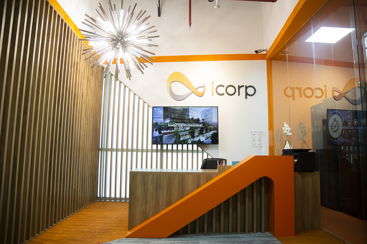 Oficina de icorp, escritorio de recepción, pantalla de fondo y el logo de icorp representando una de las 10 mejores consultoras de TI en México