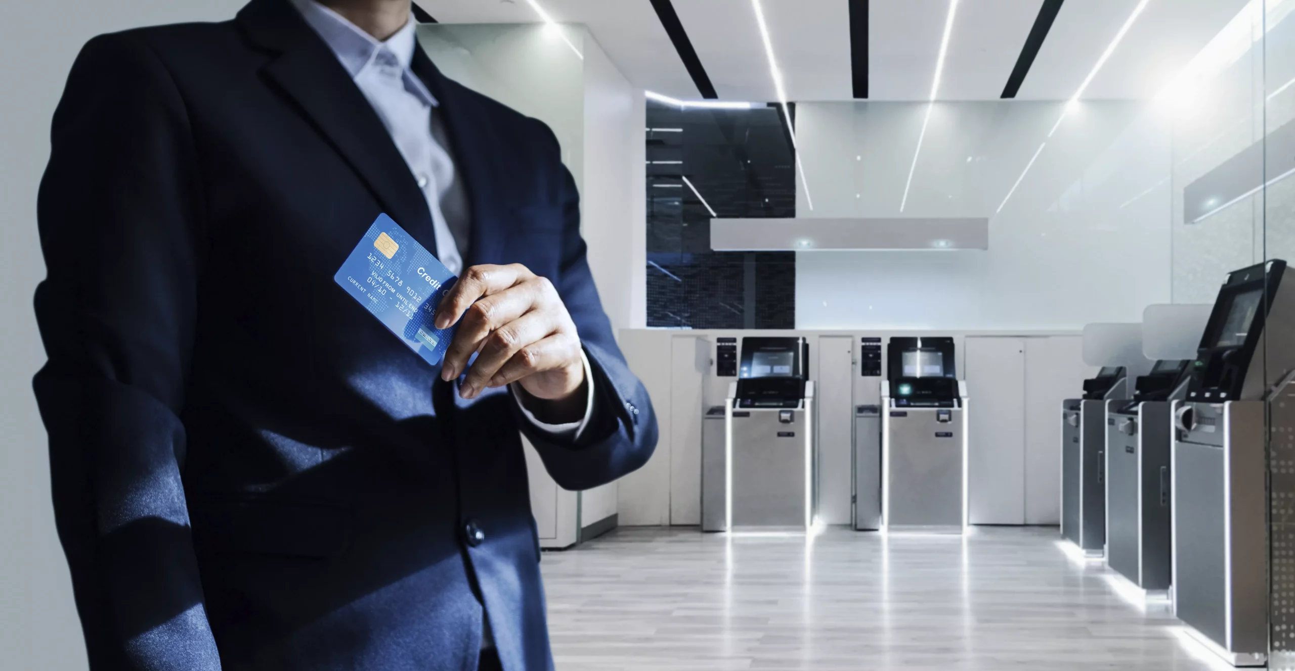 Ejecutivo dentro de un Banco mostrando una tarjeta bancaria represetnando la seguridad de datos y monitoreo de usuarios internos en el sector bancario