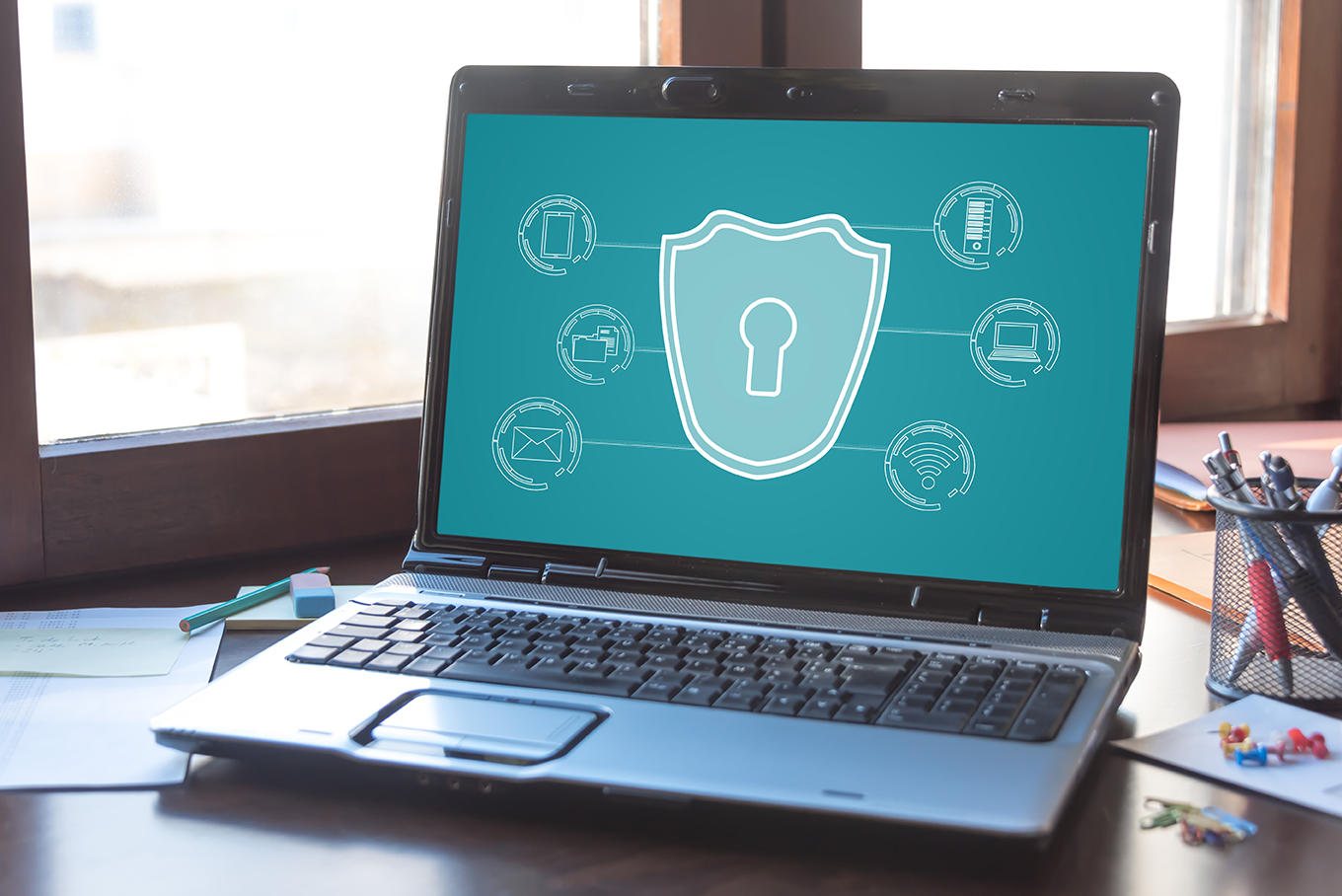 Laptop abierta sobre escritorio con fondo en la pantalla mostrando un candado de seguridad como las pruebas de penetración