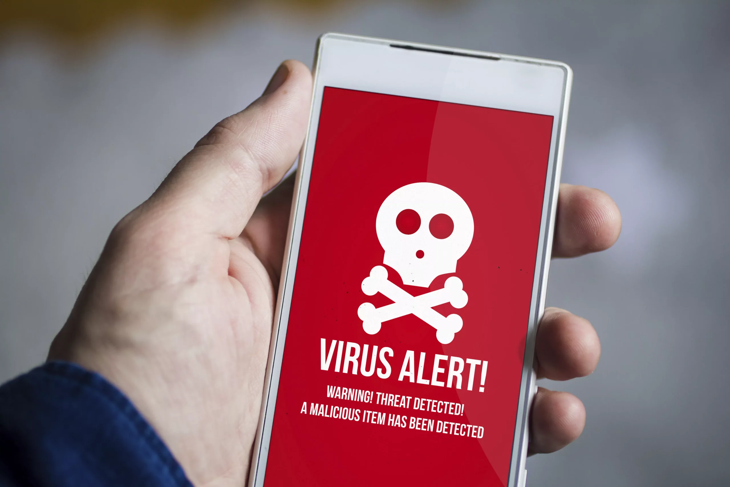 Celular con imagen de virus alert 5 Amenazas de seguridad en dispositivos móviles