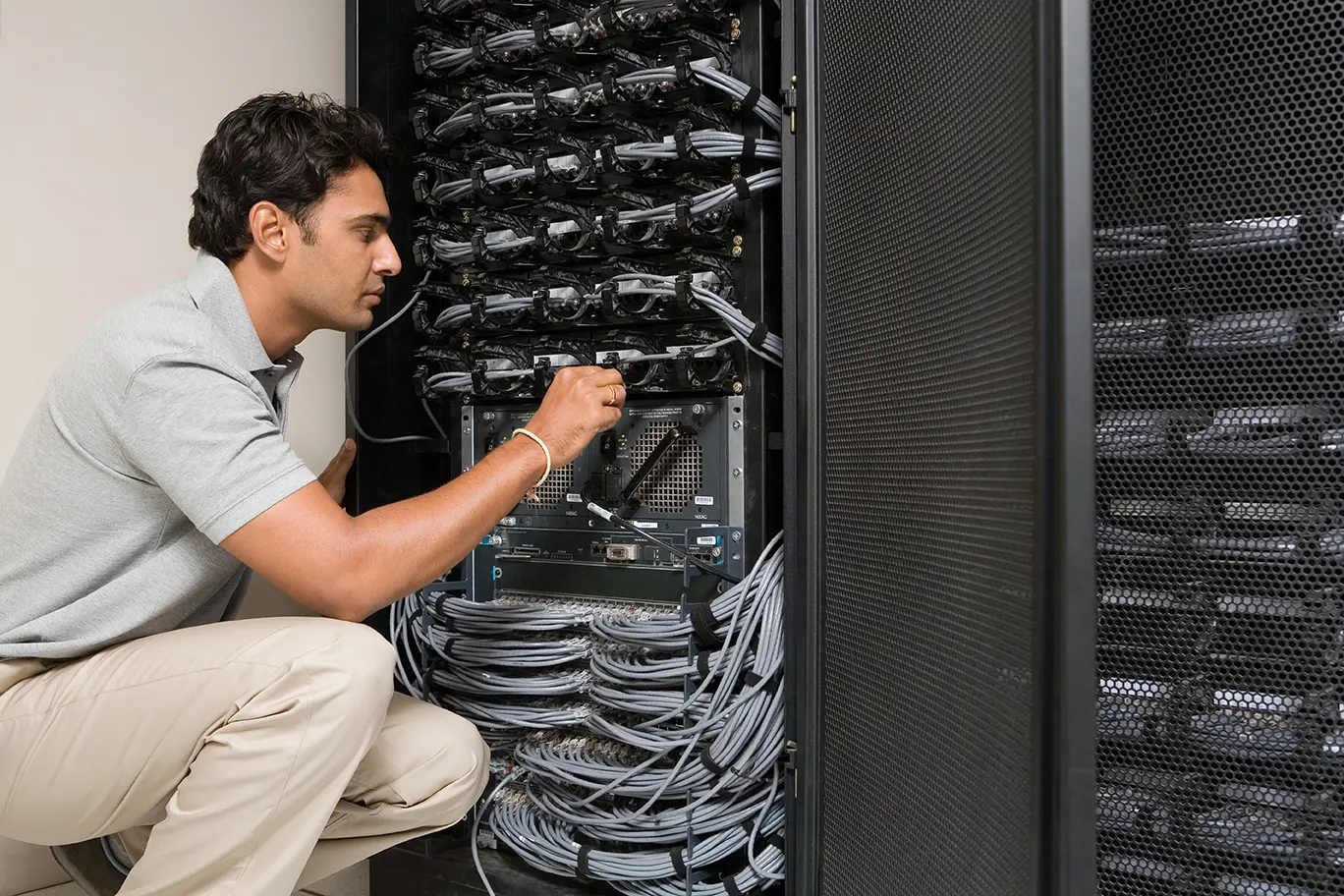 Ingeniero revisando servidores en un rack, representando 7 mitos acerca del Service Desk y el departamento de TI
