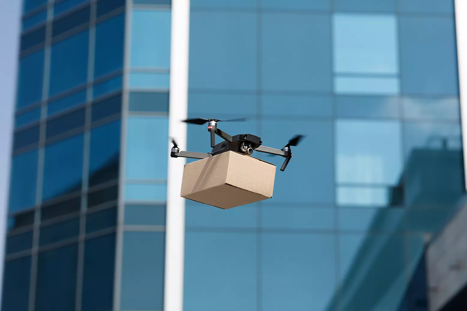 Dron volando con un paquete debajo representando que Amazon quiere hacer un dron que entienda los gestos humanos.