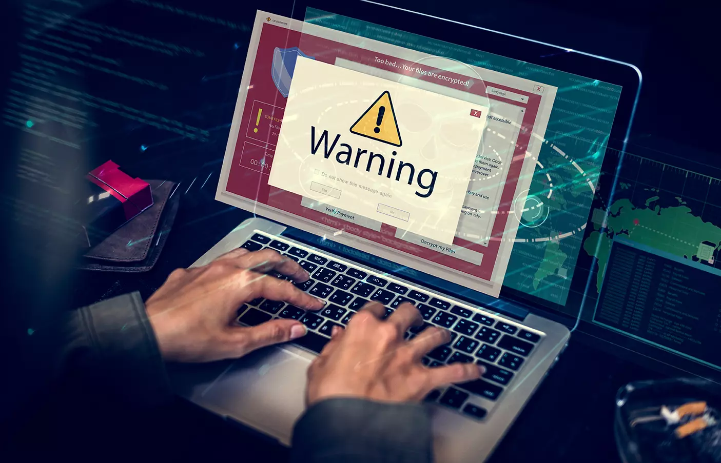 Persona frente a computadora con un letrero en pantalla de Warning, representando amenazas de seguridad de TI presentes en los activos de la organización