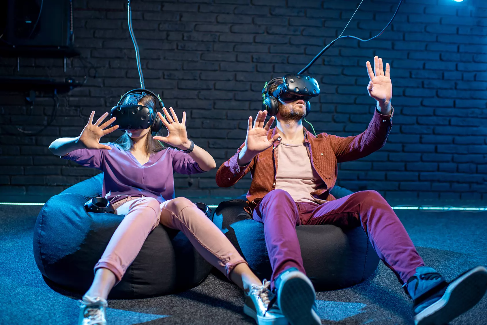 Un hombre y una mujer están sentados en una sala cada uno con visores de realidad virtual representando que Cardinal de Disney podrá convertir guiones en realidad virtual.