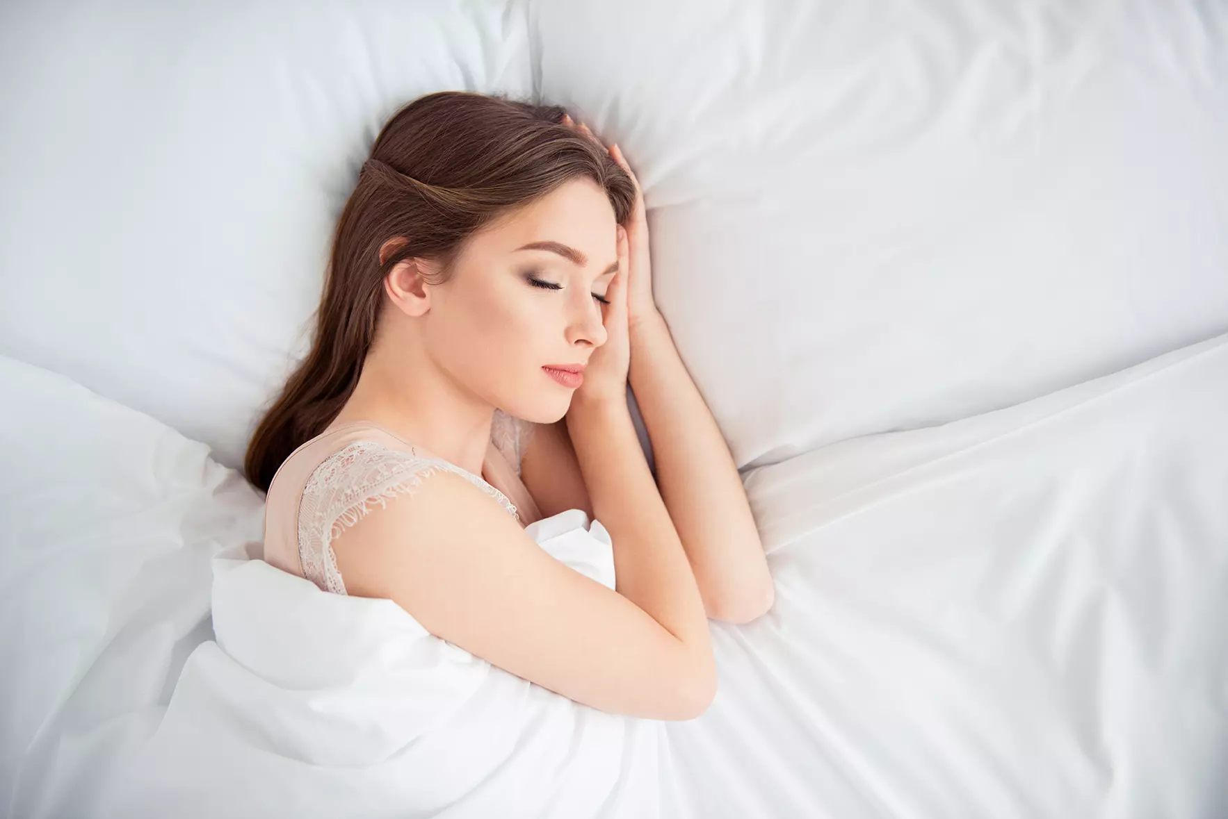 Mujer durmiendo en una cama representando a Dormio, guante creado por el MIT que puede controlar el sueño de una persona.