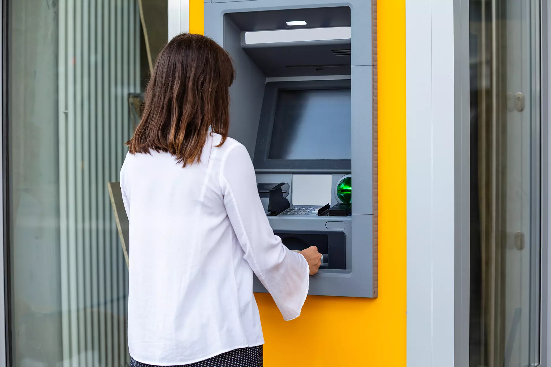 mujer en cajero automático representando que el FBI advierte sobre nueva estafa en cajeros que podría afectar a bancos de todo el mundo.