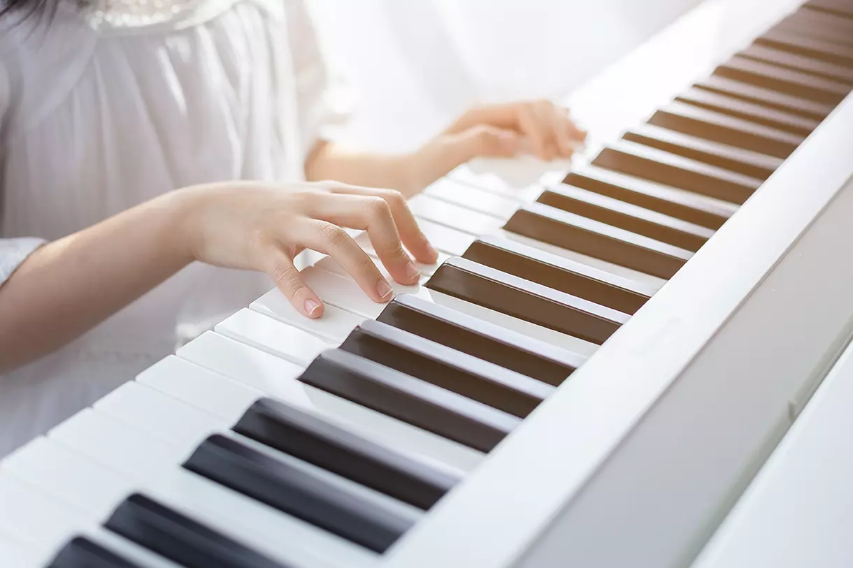 Persona tocando el piano, representando el piano inteligente que puede grabar las interpretaciones