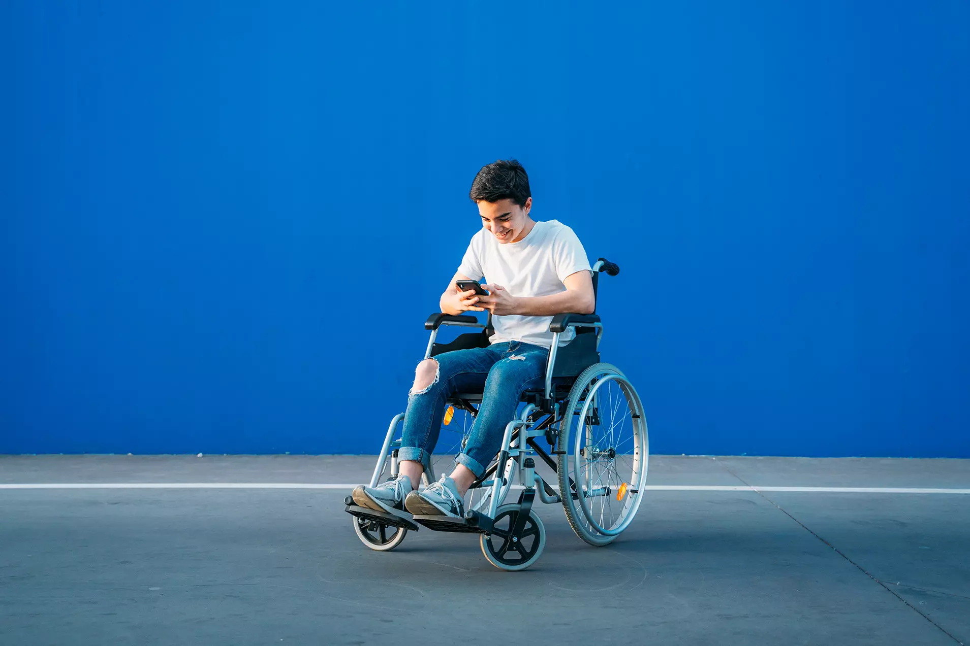 Persona en silla de ruedas usando celular representando que Google lanza nueva aplicación que permite usar sus teléfonos a personas con movilidad limitada.