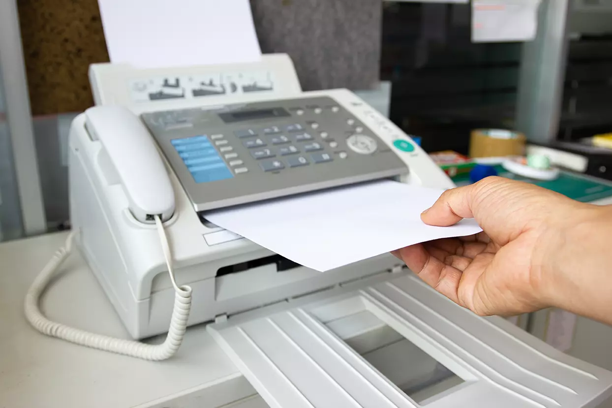 Teléfono con un fax entrante, representando cómo los hackers podrían usar los faxes para atacar las redes de las empresas.