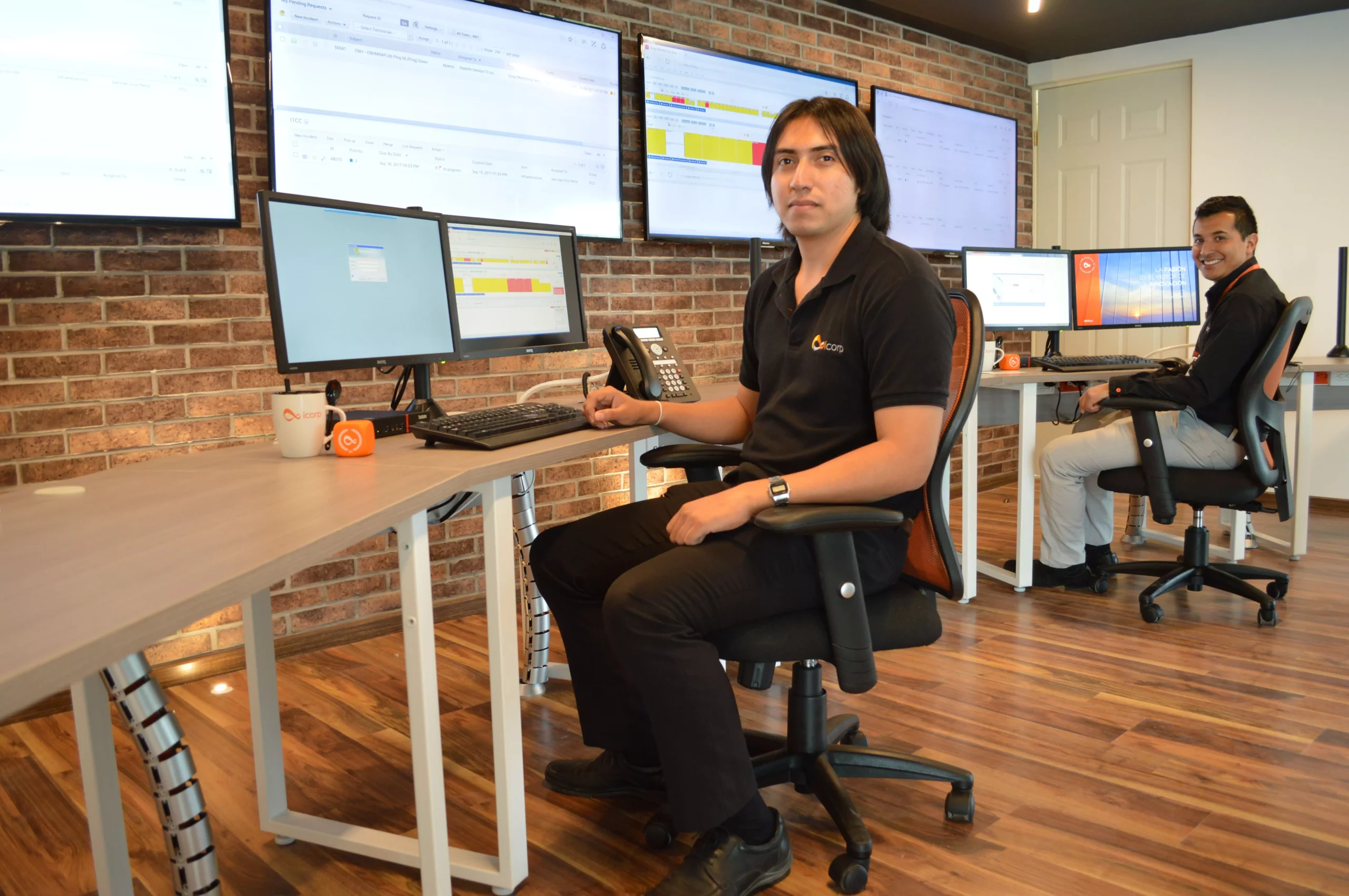 Ingeniero en oficina frente a comutadoras posando para la cámara, mostrando el IT Command Center: Ensuring business continuity.