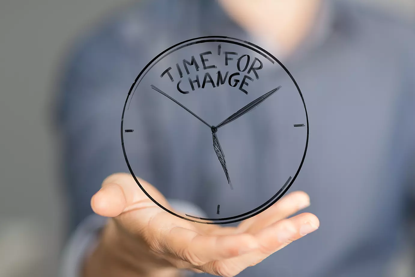 Mano sosteniendo reloj que dice: Time for change