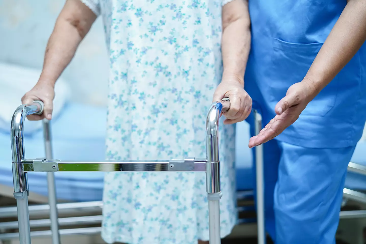 Enfermero ayudando a un enfermo con andadera mostrando como el Implante electrónico permite caminar nuevamente a persona paralizada.