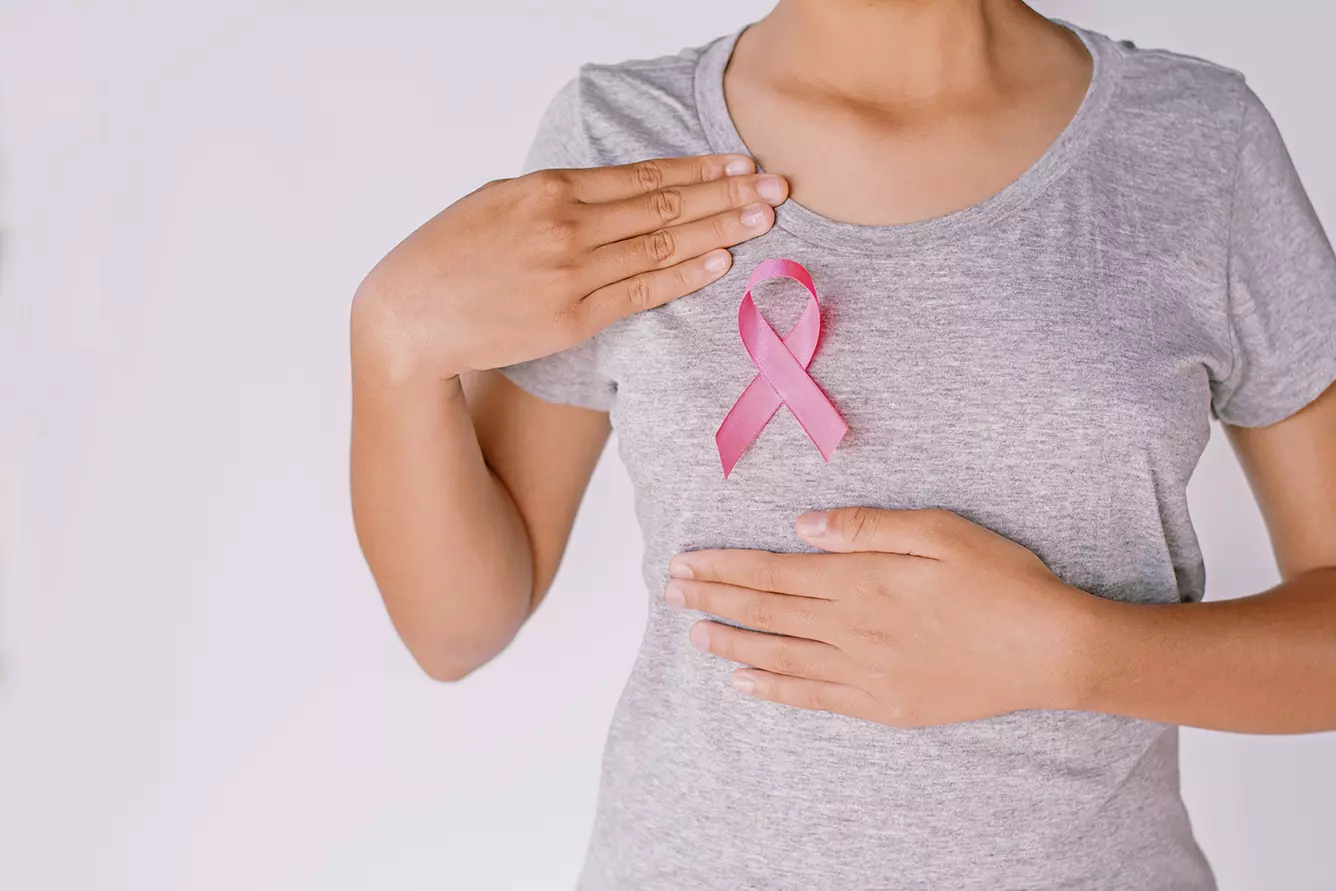 Mujer con el listón rosa de la prevención del cáncer de mama mostrando como la Inteligencia Artificial de Google puede detectar cáncer de mama con más certeza que un humano