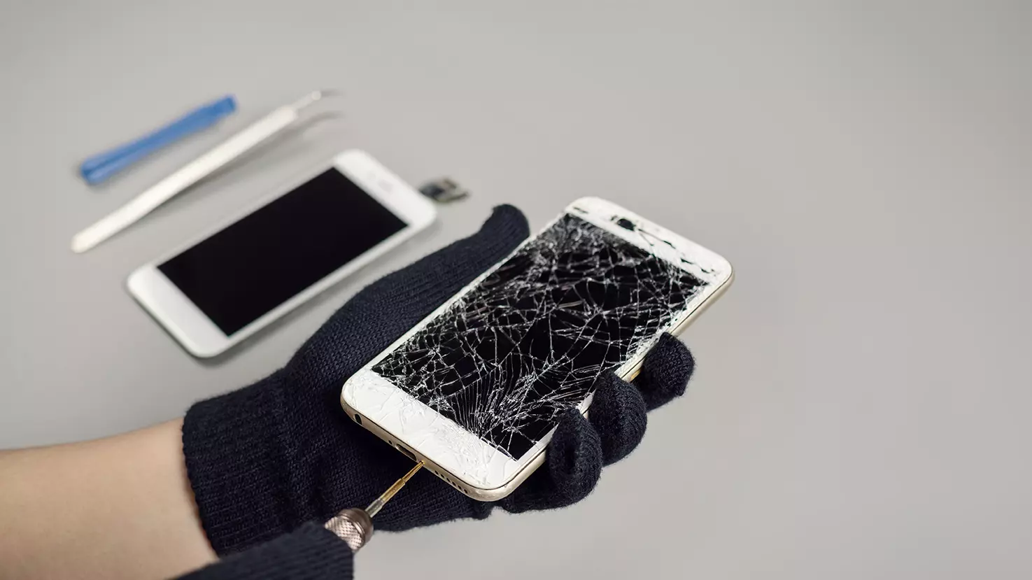 Persona arreglando una carátula de iPhone rota, representa como la parte trasera del iPhone 8 será más costosa de reparar que el display
