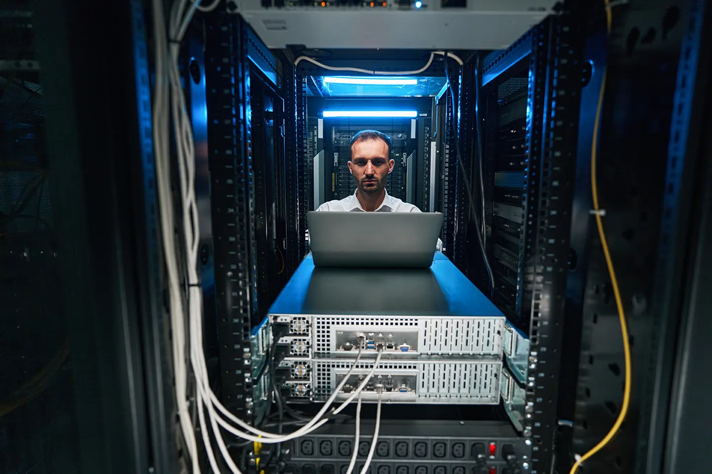 Ingeniero frente a computadora dentro de un servidor, mostrando las 8 habilidades técnicas más solicitadas por las empresas en 2018.