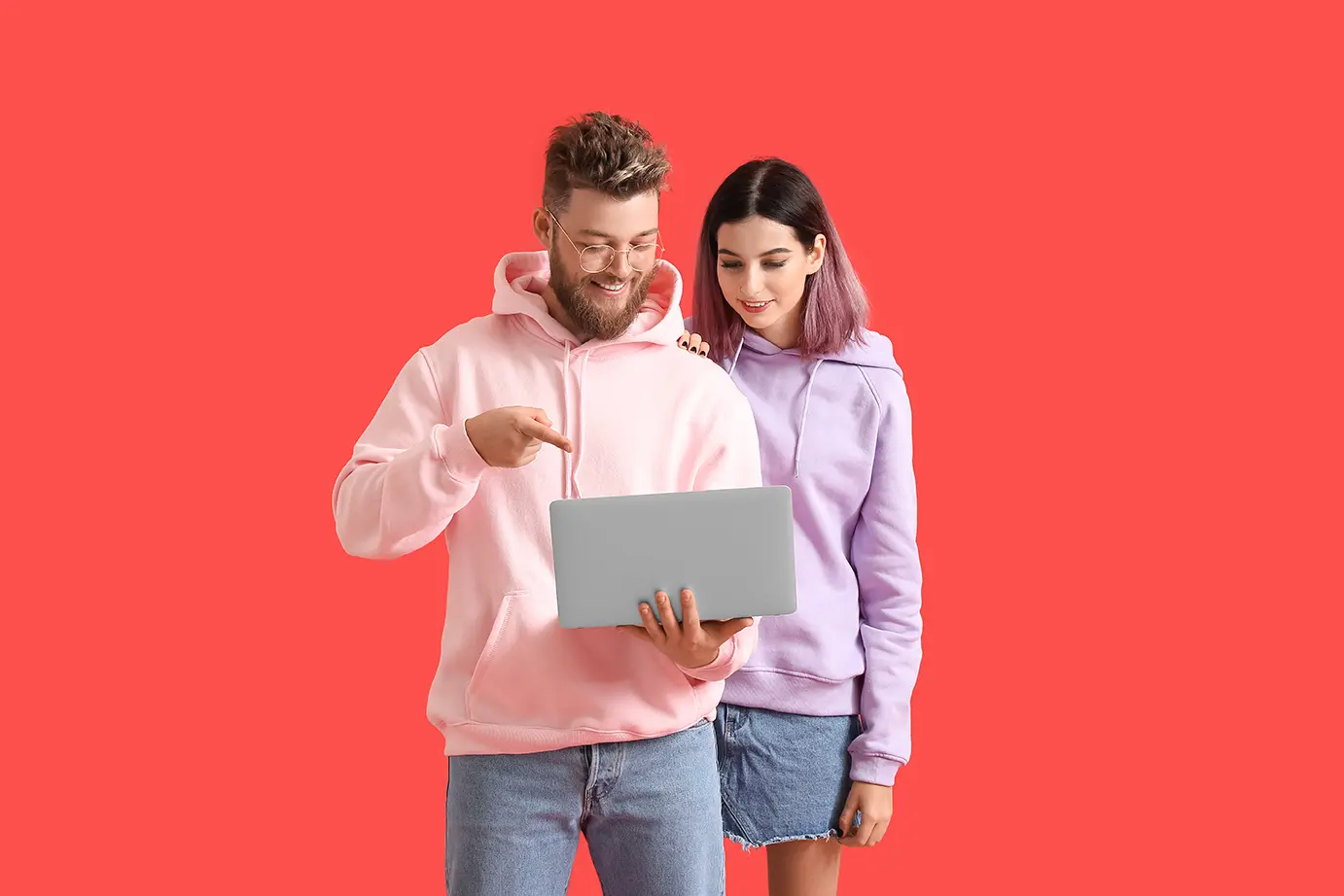 Un hombre y una mujer con una con una laptop mostrando las nuevas prendas inteligentes de Tommy Hilfiger.
