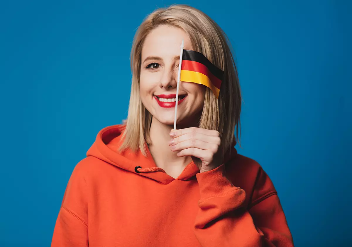 Mujer con la bandera de Alemania tapando su ojo izquierdo, representando como los alemanes podrán utilizar su iPhone como tarjeta de identidad