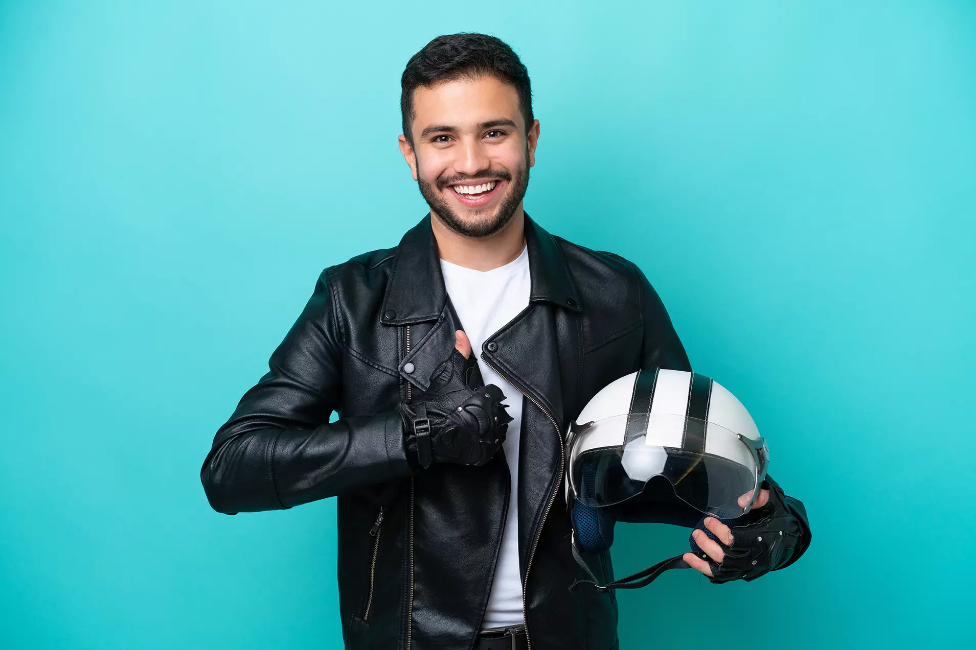 Hombre motociclista con chamarra de cuero y casco, mostrando los nuevos cascos inteligentes para motociclistas de Jarvish.