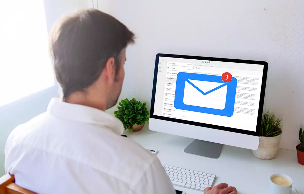 Hombre frente a computadora revisando su correo, mostrando la nueva función de Gmail que sugerirá asuntos en base a lo escrito en el correo