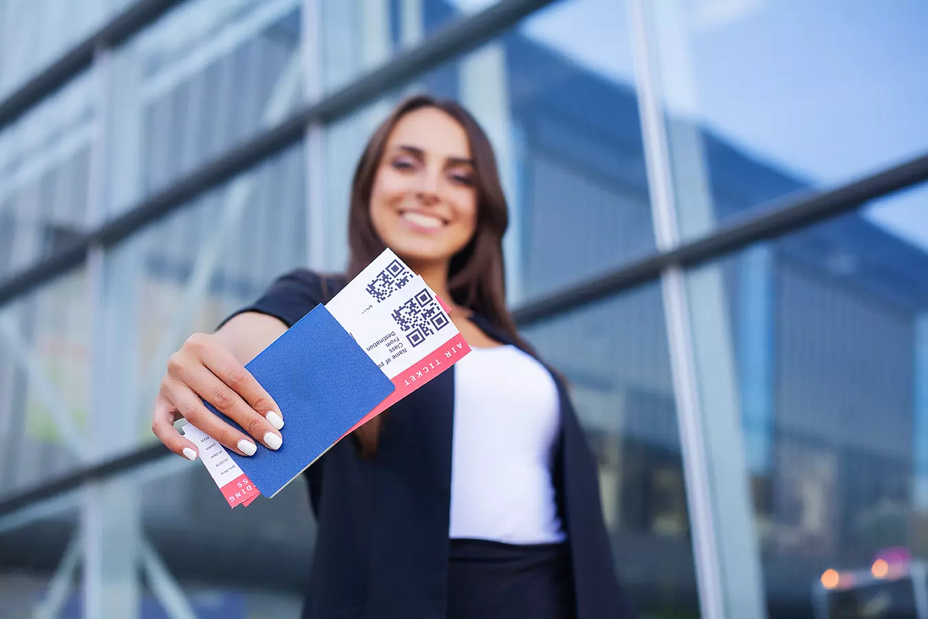 Mujer mostrando boletos de avión mostrando por qué no es recomendable publicar fotos de los boletos de avión.