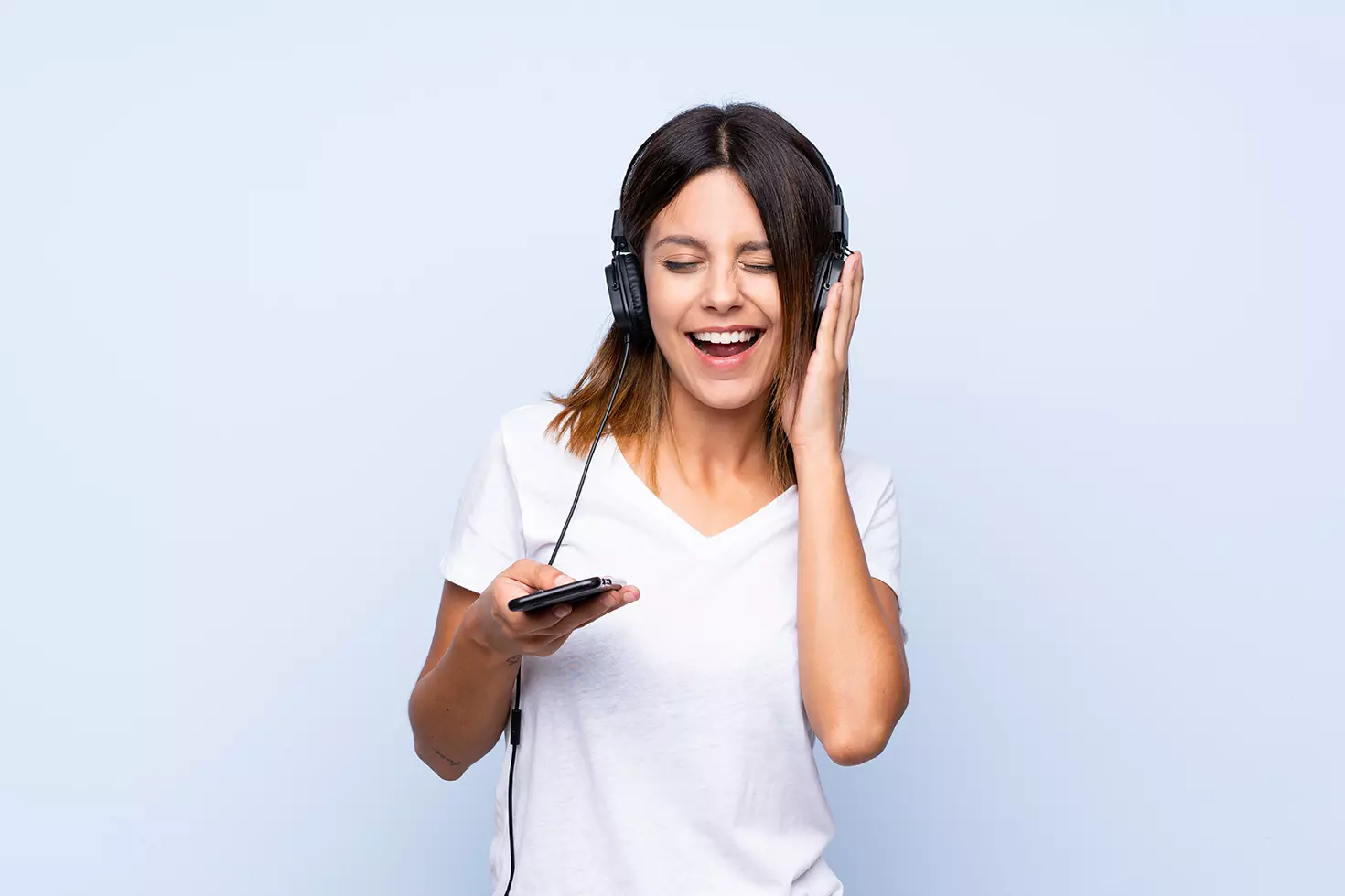 Mujer escuchando Spotify desde su celular indicando que Spotify llega a 100 millones de usuarios premium