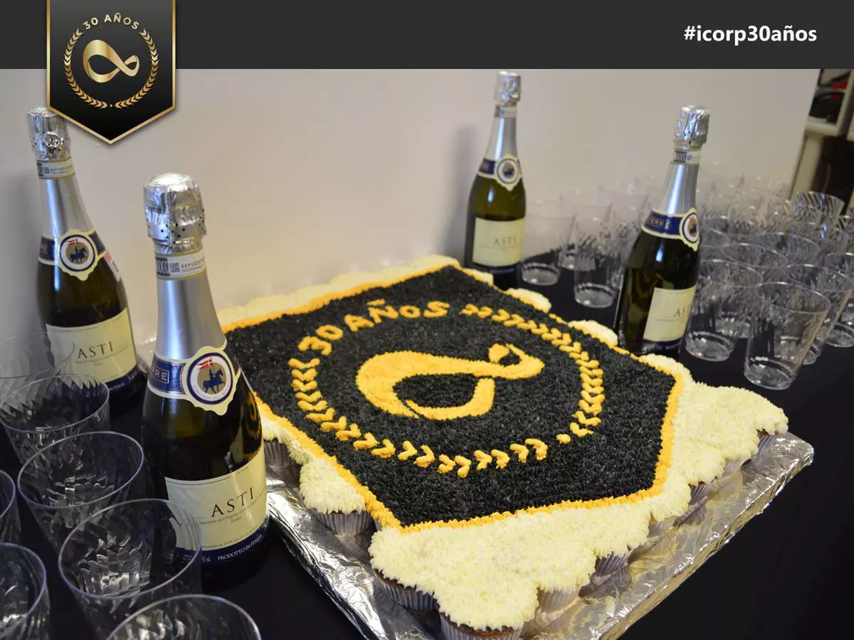 pastel con logo de icorp y champaña celebrando que icorp, empresa mexicana de TI, celebra su 30 aniversario
