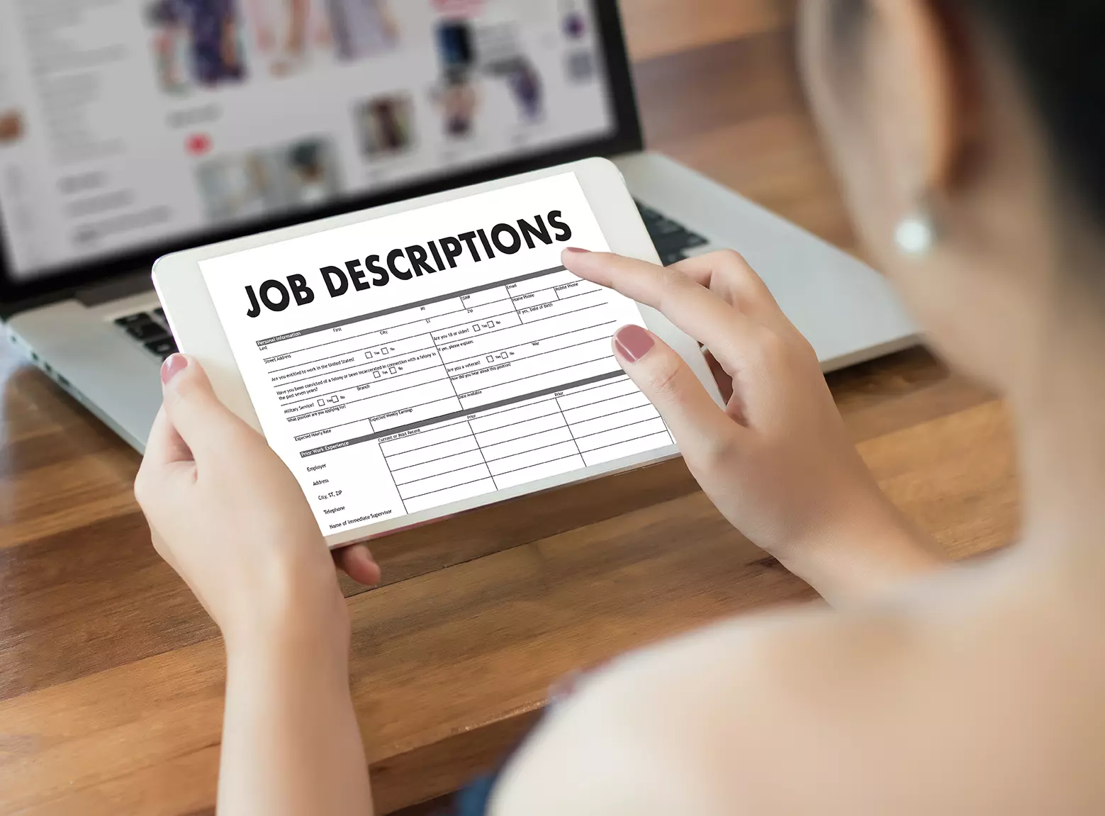 Mujer revisando en tablet la descripción de trabajo mostrando cómo elaborar un perfil de puesto de TI