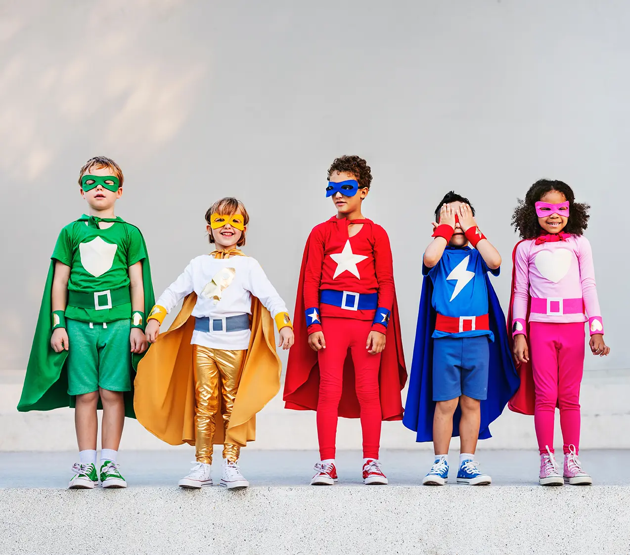 Varios niños y niñas disfrazados de super héroes representrando la formación de los niños en épocas de Iron Man