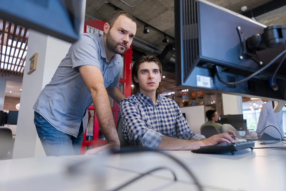2 millennials revisando información en una computadoras indicando cómo aprovechar su talento en empresas TI