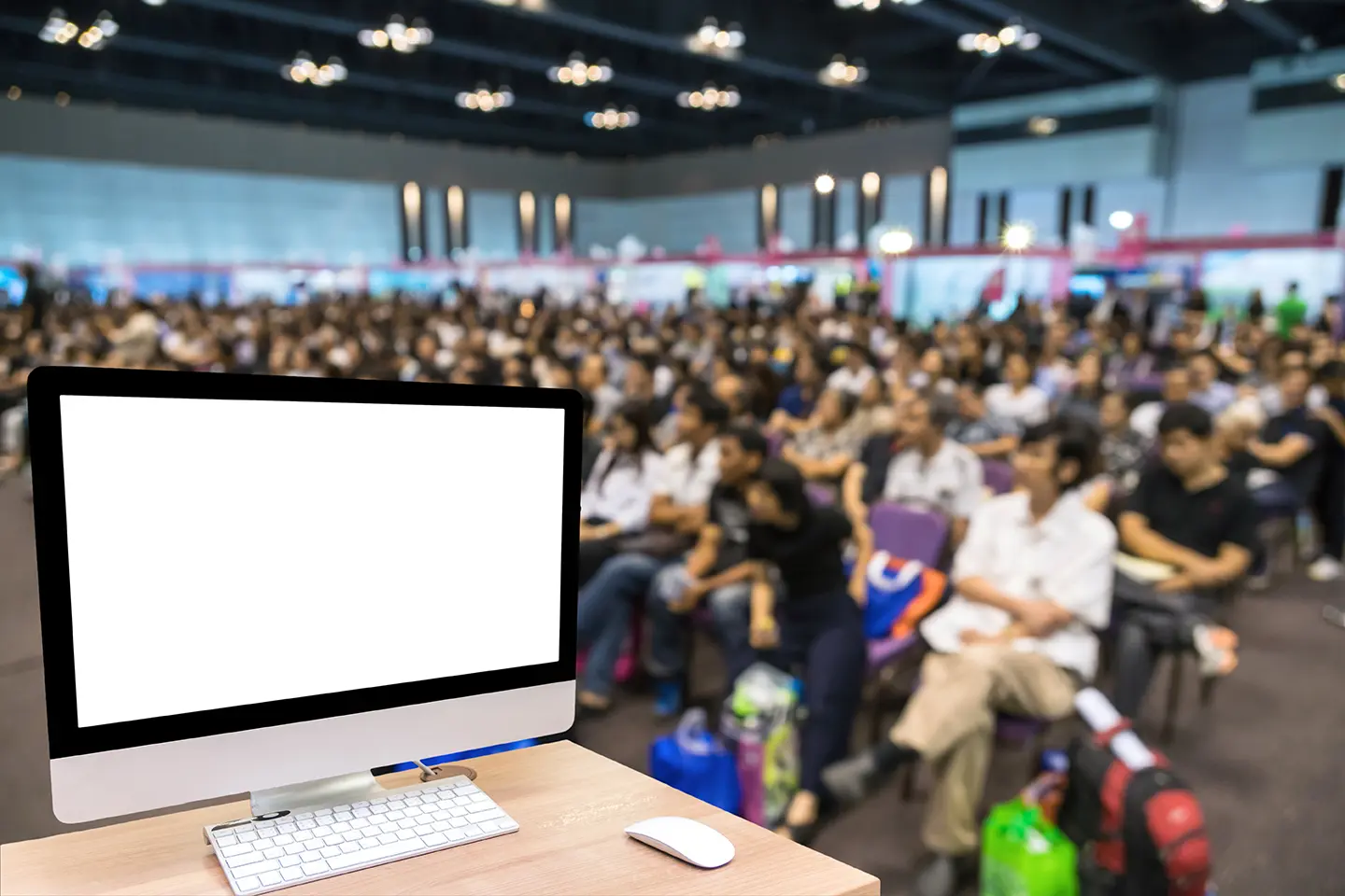 Auditorio con personas reunidas en un evento, escritorio con computadora frente a ellos, mostrando todos los eventos, ferias y congresos de TI en México 2017.