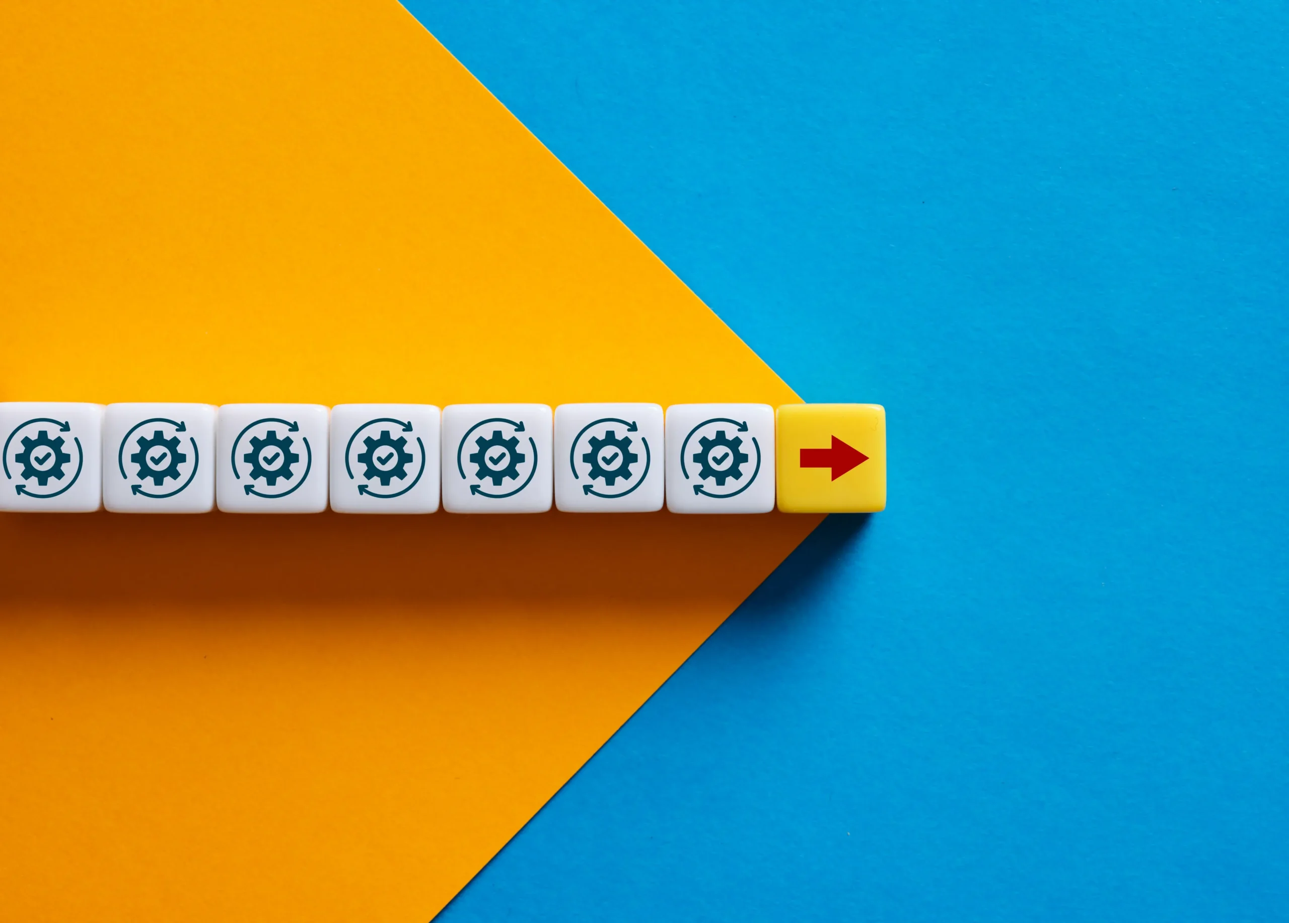 Una fila de cubos blancos con iconos de engranajes y verificación que termina en un cubo amarillo con una flecha roja, representando la evolución del CRM en 2026.